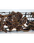 Copper batik ink block with intricate floral and central rose design, antique style, close-up view.