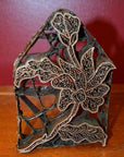 Close-up of copper Batik ink blocks with hand-designed metal ornament and intricate floral patterns on wood.