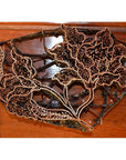Close-up of copper Batik ink blocks with intricate floral designs on a wooden surface.