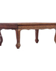 Copper coffee table with carved wooden legs and decorative patterns, displayed against a plain white background.