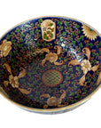 Close-up of blue, gold, green, and red Ming porcelain bowl with floral and bird patterns in very good condition.