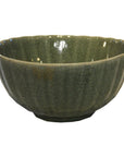 Close-up of a white celadon porcelain bowl with crackled glaze and scalloped rim on a modern white background.