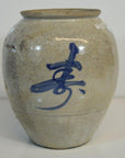 Close-up of cream crackle-glazed Japanese vase with hand-painted calligraphy, ceramic surface visible.