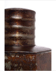Close-up of a dark metal pitcher with a ribbed cylindrical top and industrial accents against a white background.