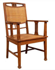 Brown teak armchair with rattan seat and back, Dutch Colonial Javanese style, featuring triglyph-inspired motifs.