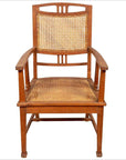 Brown teak Dutch Colonial Javanese armchair with rattan seat and triglyph motifs, front view.