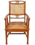 Brown teak Dutch Colonial Javanese armchair with rattan seat and triglyph motifs, front view.