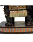 Painted ceramic elephant garden stool with dark-colored elephant-like lower legs, close-up view.