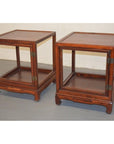 Pair of light wood Elmwood side tables with open sides, lower shelves, and hinged doors on a gray floor.
