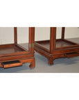 Brown Elmwood side tables with carved legs and pull-out trays, placed on a light-colored floor.