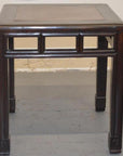 Dark wood stool with straight legs, geometric burlwood inlay pattern beneath seat, studio close-up.