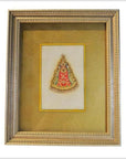 Close-up of framed Indian artwork featuring a small Hindu deity in red and gold on a radiant golden background.