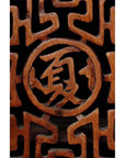 Close-up of dark wood Chinese cabinet with carved fretwork doors and visible Chinese character detail.