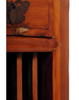 Close-up of a dark wood Chinese cabinet corner with carved fretwork, vertical slats, and butterfly metal hardware.