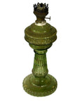 Close-up of green glass oil lamp with ribbed base and brass burner, in very good condition.