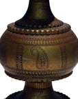 Close-up of a silver hammered metal Indian urn with engraved patterns and ornate decorative designs.