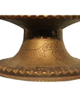 Close-up of bronze Hammered Indian urn with engraved owl motifs on the base.