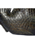 Close-up of bronze hand carved fish sculpture with detailed scales and fins on white background.