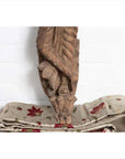 Brown stone hand carved Indian temple statue of Hindu deity from Gujarat, traditional design, on plain background.