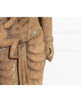 Brown stone statue of mother and child from Gujarat, hand carved with textured worn clothing, close-up.