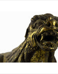 Brown wood close-up of hand carved Indonesian beast statue with open mouth, sharp teeth, and visible cracks.