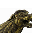 Bronze mythical creature head with open mouth, sharp teeth, textured fur, and subtle cracks, close-up.