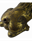 Close-up of gold and black hand-carved Indonesian lion paw with detailed fur, missing tail, hollow near claws.
