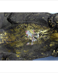 Close-up of weathered gold hand carved Indonesian beast statue with cracks and red and white paint patches.