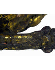 Close-up of gold-painted carved wood animal paw showing detailed toes, visible texture, and cracks from use.