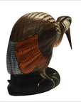 Close-up of a brown, orange, and blue hand-carved wooden Indonesian kiwi bird on a black base.