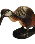 Brown, black, and white hand-carved wooden kiwi bird on black base, hand-painted, indoors.