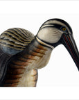 Close-up of a wooden bird figurine with detailed feathers, brown color, about 10 inches, indoors.