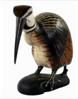 Brown, white, and gray hand carved Indonesian kiwi bird with feather details and long black beak, close-up view.