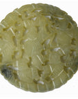 Close-up of round, light green-yellow jade medallion with abstract carvings, 2⅛-inch diameter, very good condition.