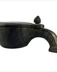 Dark rustic hand-carved mortar made of wood, displayed against a plain white background, close-up view.