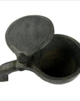 Black metal mortar with sliding top cover and short handle, open, on plain background.