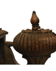Close-up of brown teak wood architectural element with rounded ribbed design and pointed top.