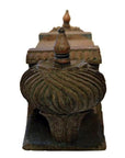 Brown teak wood architectural element with swirling carvings and pointed finials, isolated on a white background.