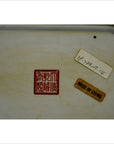 Close-up of bottom of white porcelain tray with hand painted European design, red Chinese seal mark, MADE IN CHINA label.