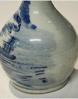 White ceramic vase with hand painted blue ship and water scene, round shape, close-up on plain background.