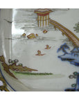 Close-up of a multicolor porcelain Imari bowl with hand painted bridge, water, boats, and landscape design.