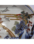 Close-up of hand painted Imari porcelain bowl with trees, birds, and pagoda by bridge design; minor casting marks visible.