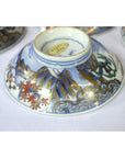 Blue, gold, and red ceramic plate with floral design, shown from the bottom.