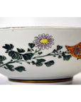 Porcelain bowl with green leaves, purple-yellow flower, and red-yellow geometric pattern, 7-inch diameter.
