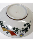 White porcelain bowl with hand painted floral and gold ribbon designs, upside down on white background, 7 inch diameter.