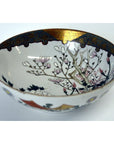 White porcelain Kutani bowl with gold trim, hand painted pink flowers and blooming branches, 7 inch diameter.