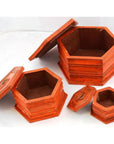 Close-up of three hand painted octagonal boxes with lids, nested together on a white background.