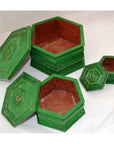 Hand painted octagonal wooden boxes with lids, open and nested together on a white surface.