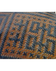 Close-up of a brown and black rattan basket with geometric pattern.