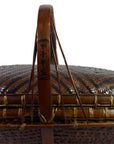 Close-up of a handwoven rattan basket with handle in natural color, featuring black Chinese characters.